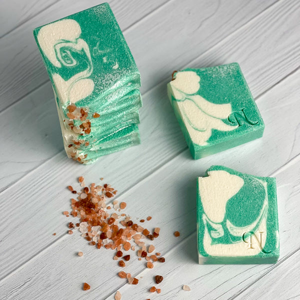 Aura Salt Soap - 3 teal green and white soaps stacked in pile of 3 and 2 laying flat on the side, coarse Himalayan salt as prop